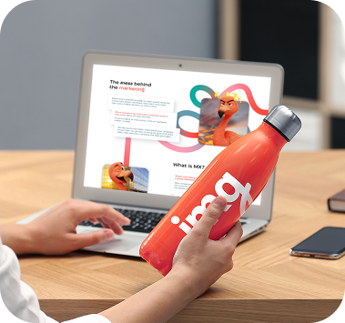 Branded drinks bottle beside a laptop on a desk